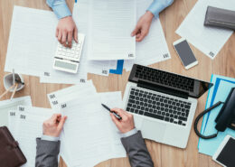 Business people working at office desk, they are checking tax forms and calculating costs, finance and management concept