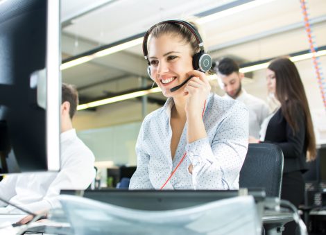 Smiling agent woman with headsets. Portrait of call center worker at office.